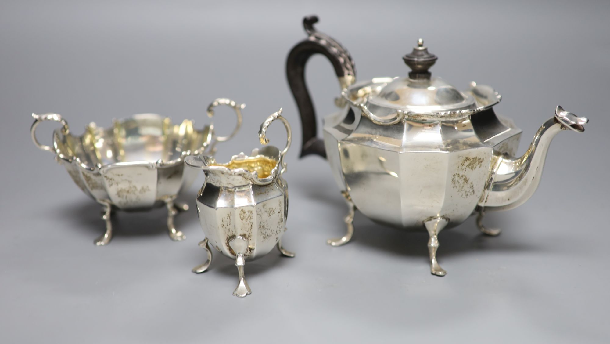 A late Victorian three-piece silver tea service of shaped stylised outline, J. R. Ltd, Birmingham 1898, gross 16.16oz